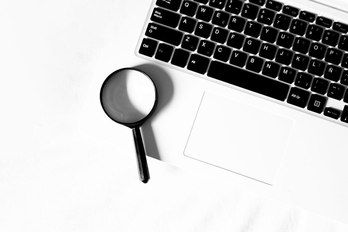 Magnifying Glass on Top of a Computer. Research Concept.